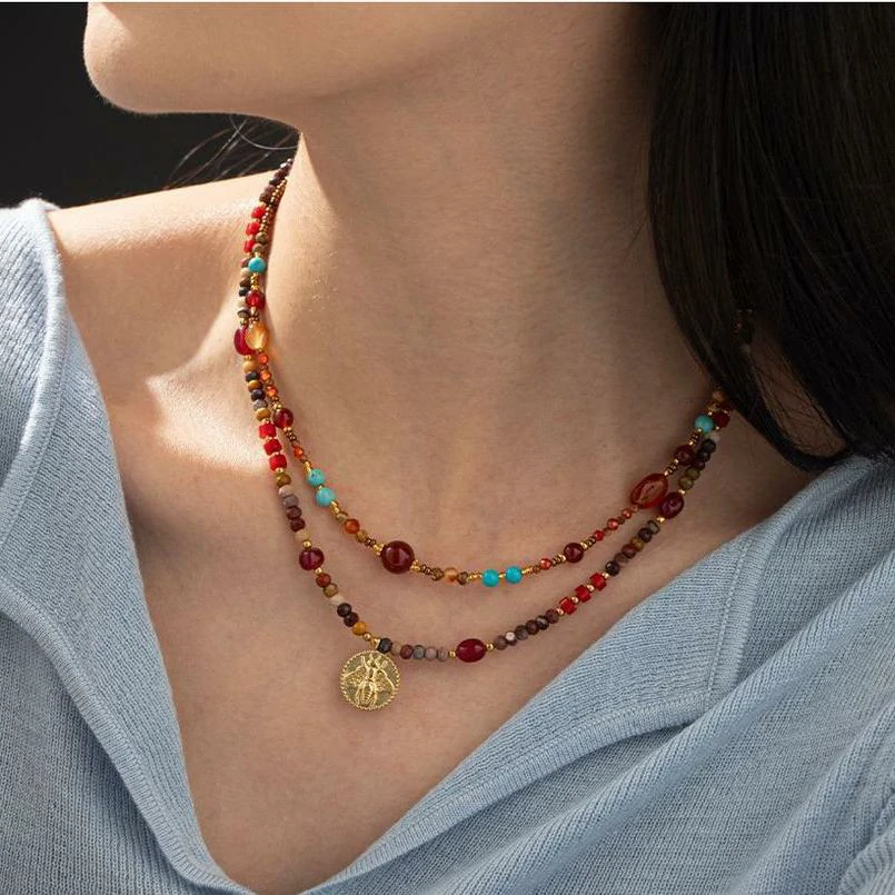 LIVKE surgical steel necklace with red agate and turquoise beads, layered with minimalist chains for boho-chic styling
