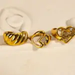 Vintage Love Signet Ring 8 Woman wearing LIVKE gold love signet ring while holding cappuccino in Parisian café, showcasing stackable jewelry styling