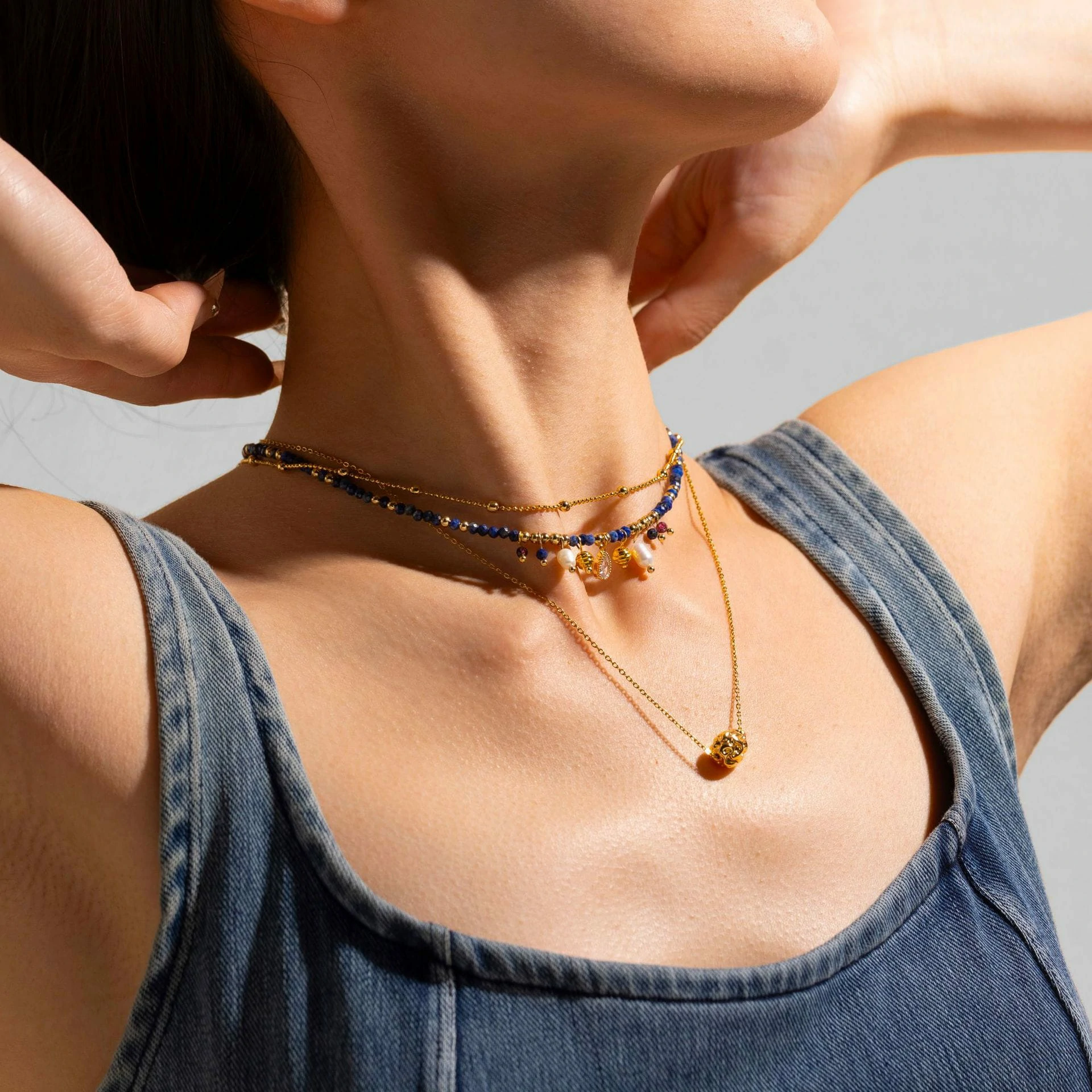 LIVKE 18K gold-plated layered necklace with colored pearls and zirconia, styled with linen and seashells for coastal minimalist aesthetic