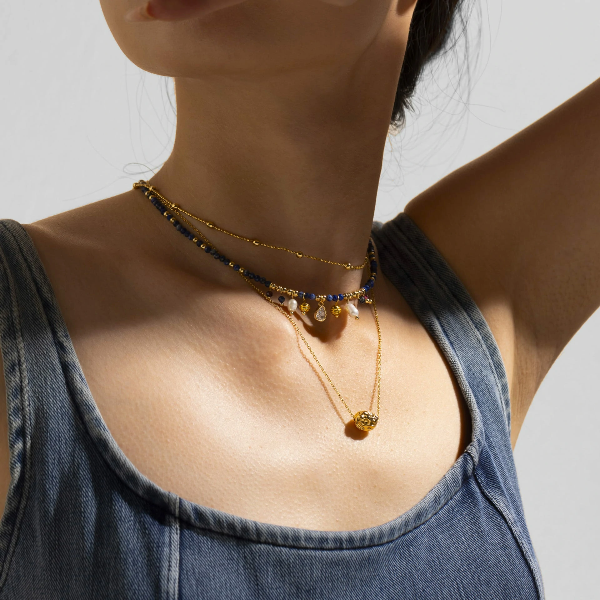 LIVKE 18K gold-plated layered necklace with colored pearls and zirconia, styled with linen and seashells for coastal minimalist aesthetic