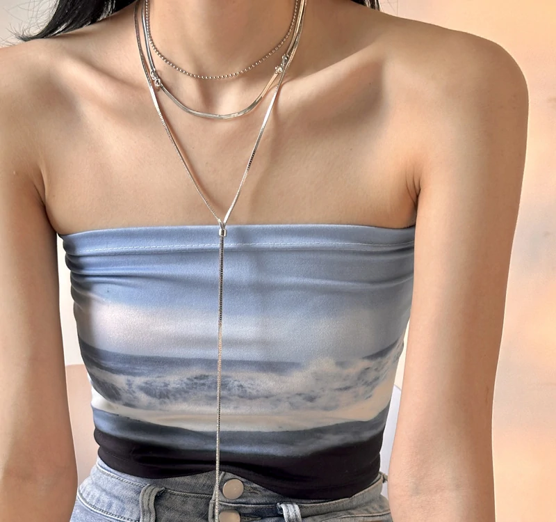 livke-white-gold-bow-necklace-bridal-luxury-layering (7) Bride wearing LIVKE white gold bow necklace with off-shoulder wedding dress, showcasing elegant bridal jewelry under sunset light