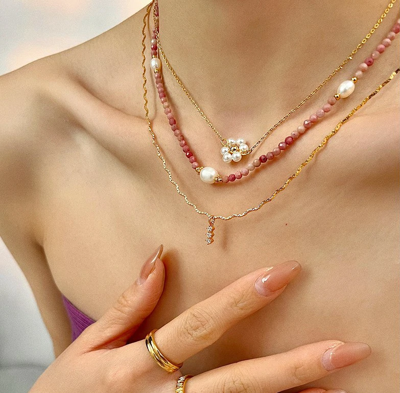 Close-up of LIVKE Y2K mystic necklace with raw amethyst, pearl, and cubic zirconia on model with holographic eyeshadow, showcasing edgy boho jewelry