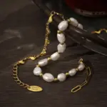 Golden Love Cascade Bracelet 3 18K gold plated chain bracelet with twelve engraved heart charms, blending Edwardian elegance with modern minimalist jewelry trends