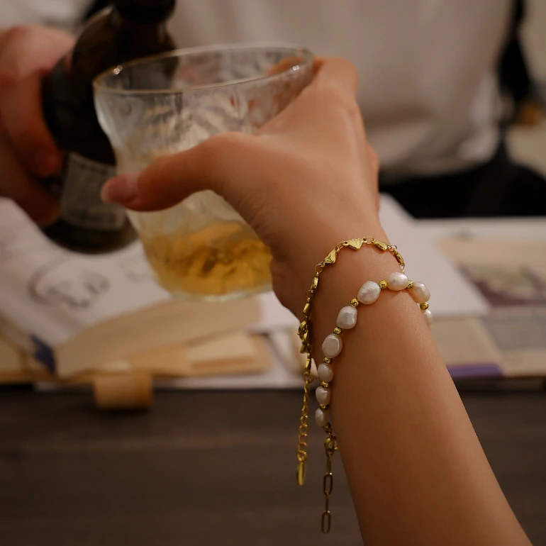 18K gold plated chain bracelet with twelve engraved heart charms, blending Edwardian elegance with modern minimalist jewelry trends