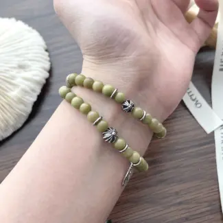 Olive green aventurine bead bracelet with silver feather charm and floral spacer beads, designed for spiritual healing and crystal energy jewelry lovers
